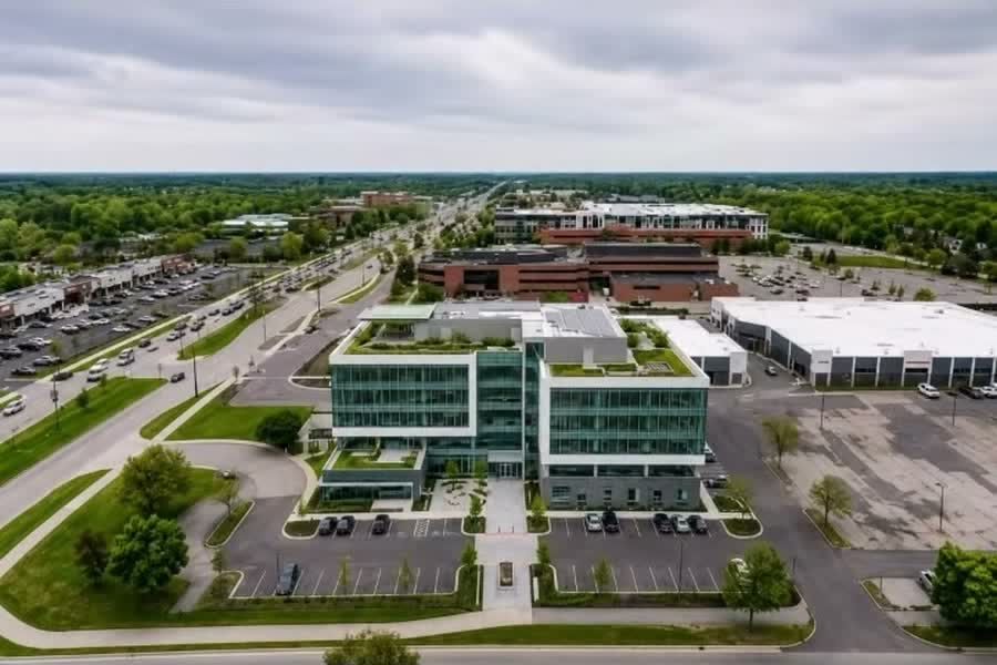 Redevelopment concept: a glass corporate office building drawn onto the subject site in an aerial view of the Orchard Lake Road corridor.